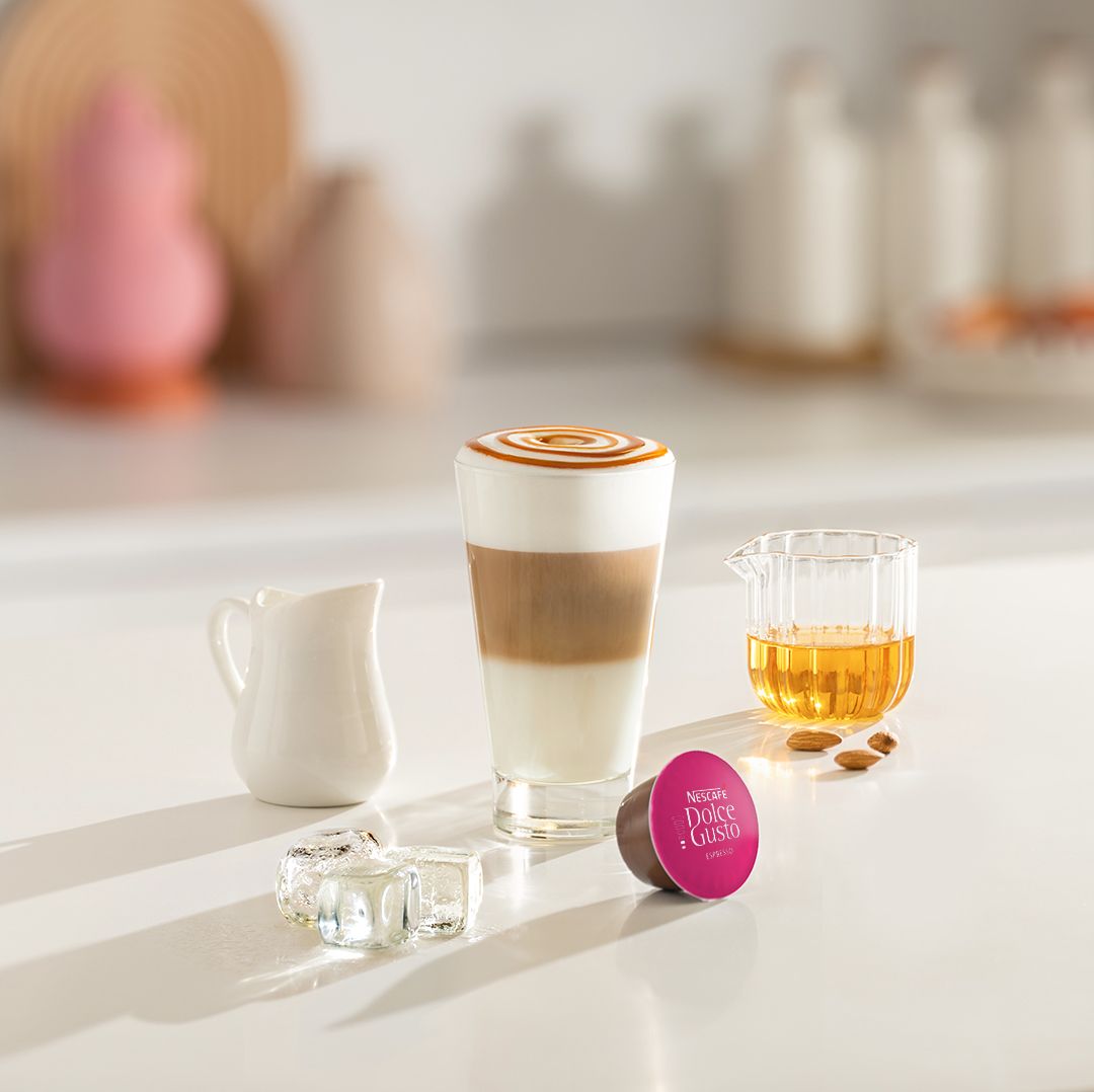 iced cappuccino next to a coffee capsule